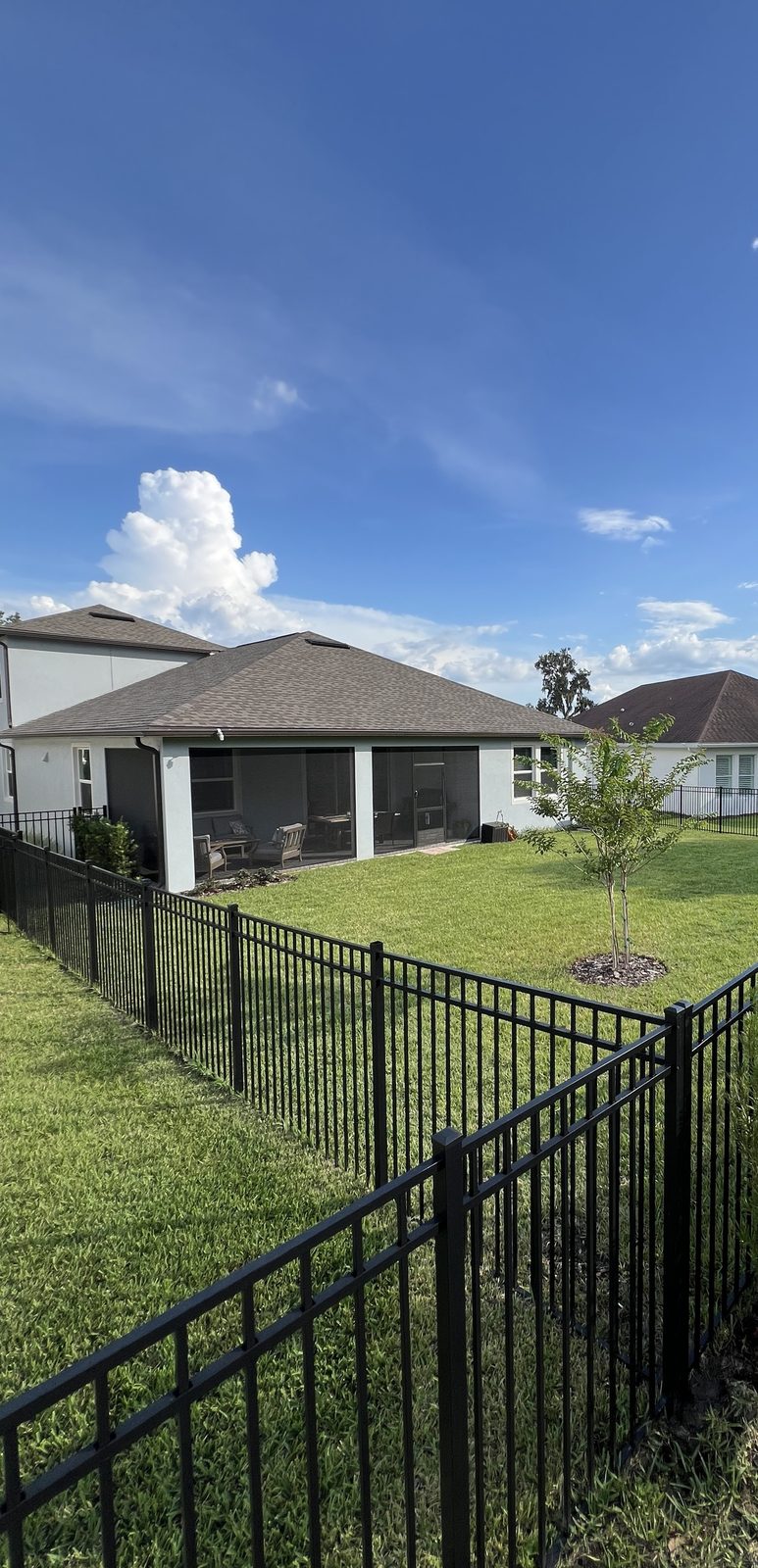 Black aluminum fence enclosing a backyard in a Florida HOA community, installed by Florida Friendly Fencing