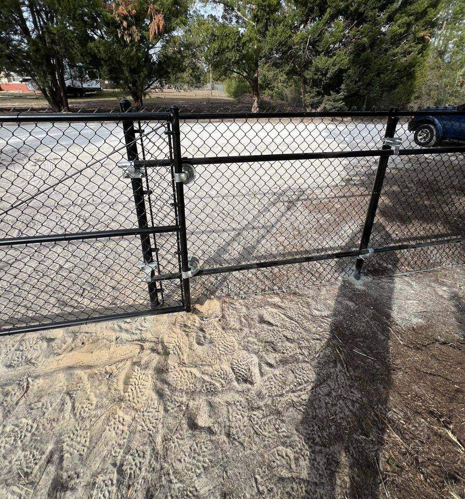 Black chain link rolling gate with wheels and guide rollers for driveway access, Florida