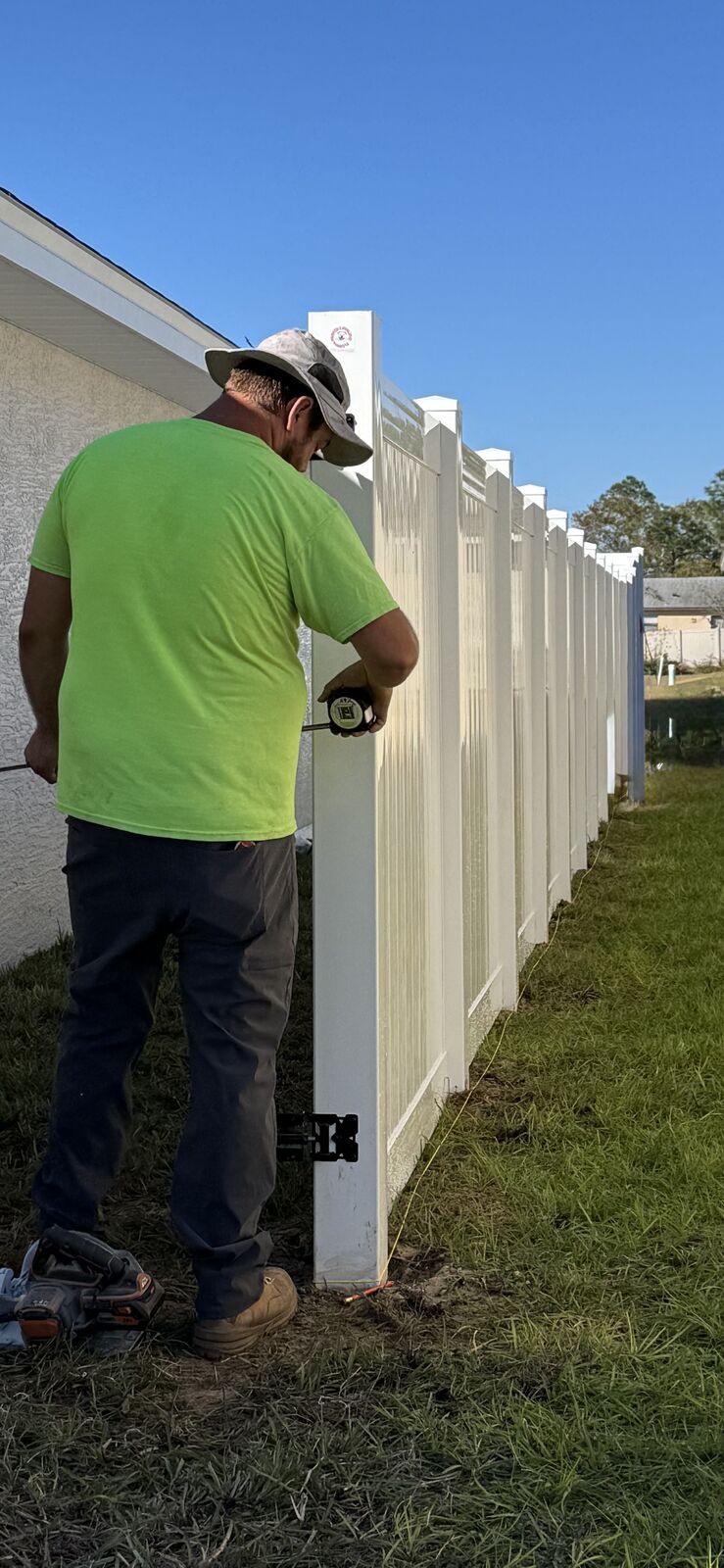 Florida Friendly Fencing crew installing white vinyl privacy fence posts