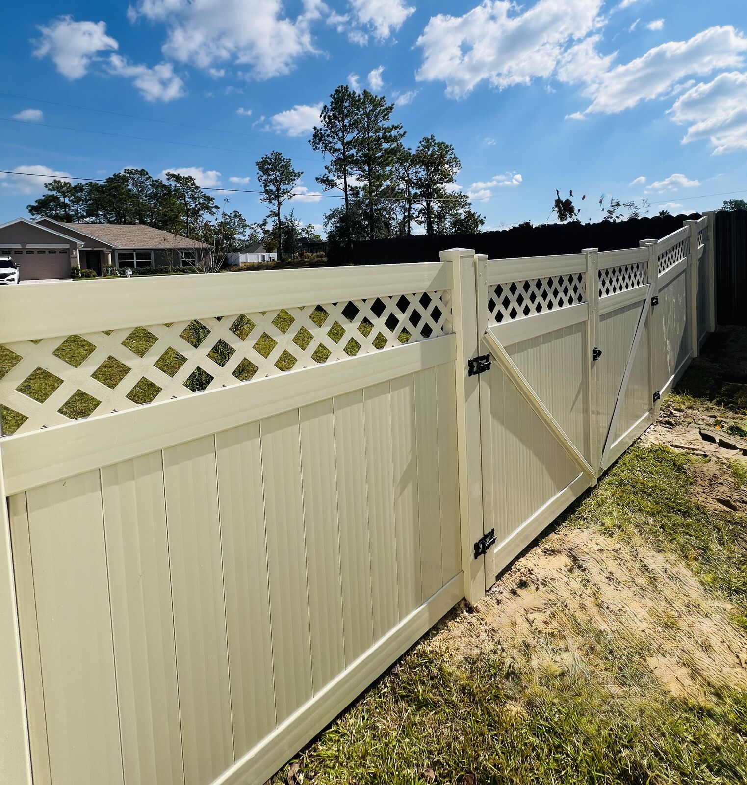 Tan vinyl privacy fence with lattice top installed in Florida