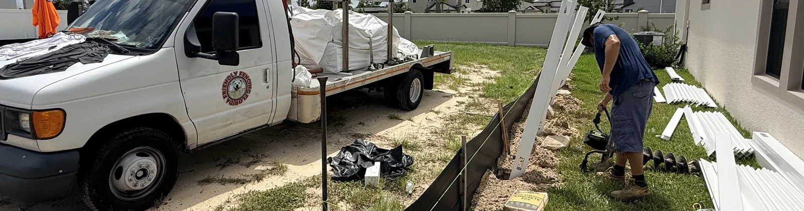 Florida Friendly Fencing crew setting vinyl fence posts on a job site