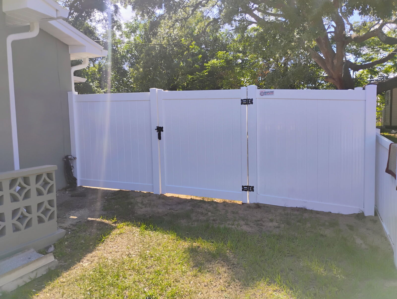 White vinyl privacy fence with walk gate and double gate installed in Florida
