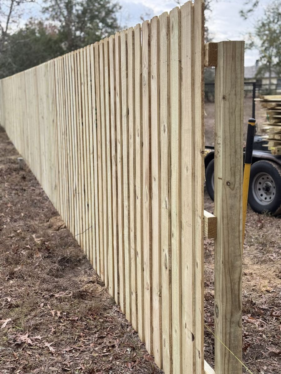 New 6 ft dog-ear wood privacy fence, finished picket side, pressure-treated pine installation in Florida