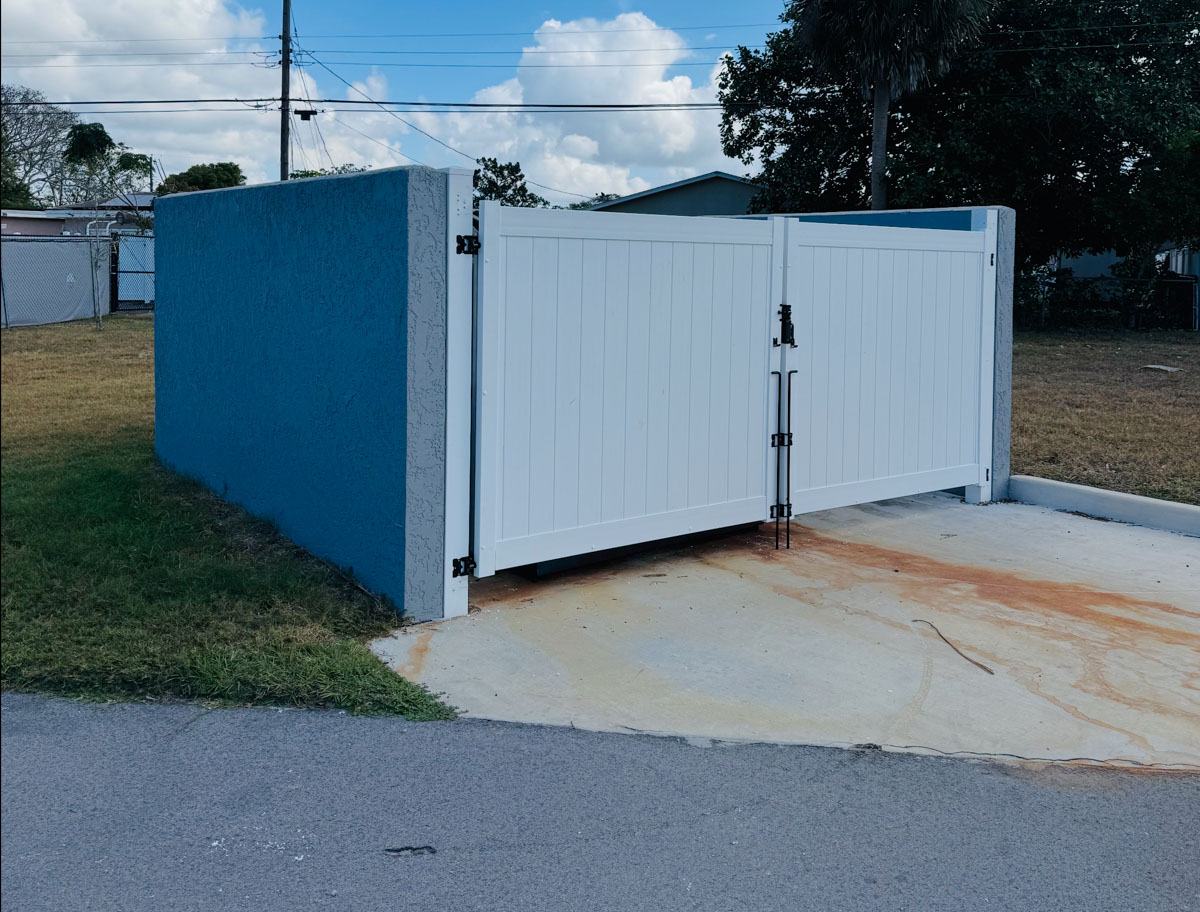 White vinyl dumpster enclosure with double swing gates in Brooksville, FL