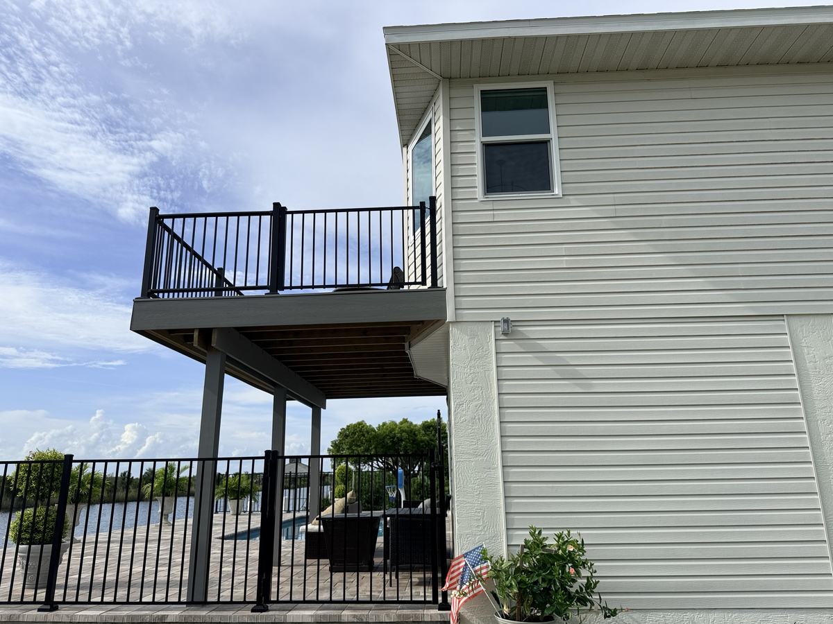 Black aluminum pool fence and matching balcony railing gate in Hernando Beach, FL