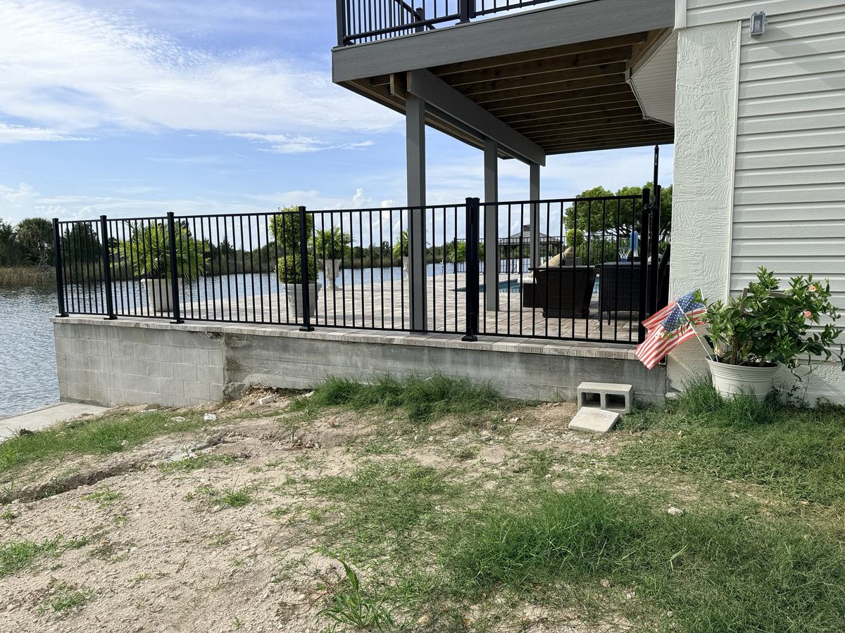 Black aluminum fence along a seawall on a Hernando Beach canal home