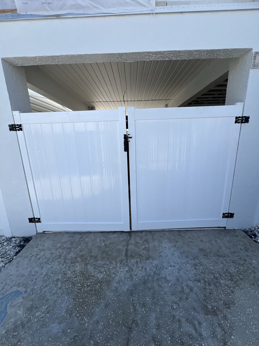 Outside view of white vinyl double gates on an elevated Hernando Beach home