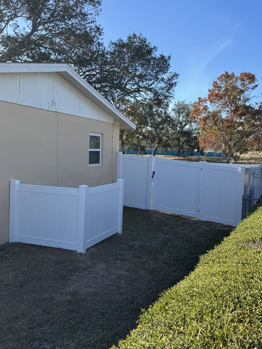 White vinyl AC enclosure beside privacy fence gates in Hernando County, FL