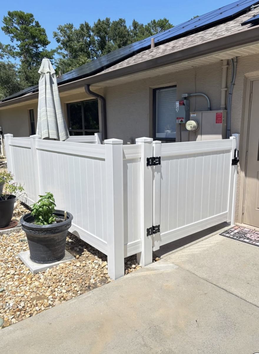 White vinyl enclosure with a gate around a utility meter in Hernando County, FL