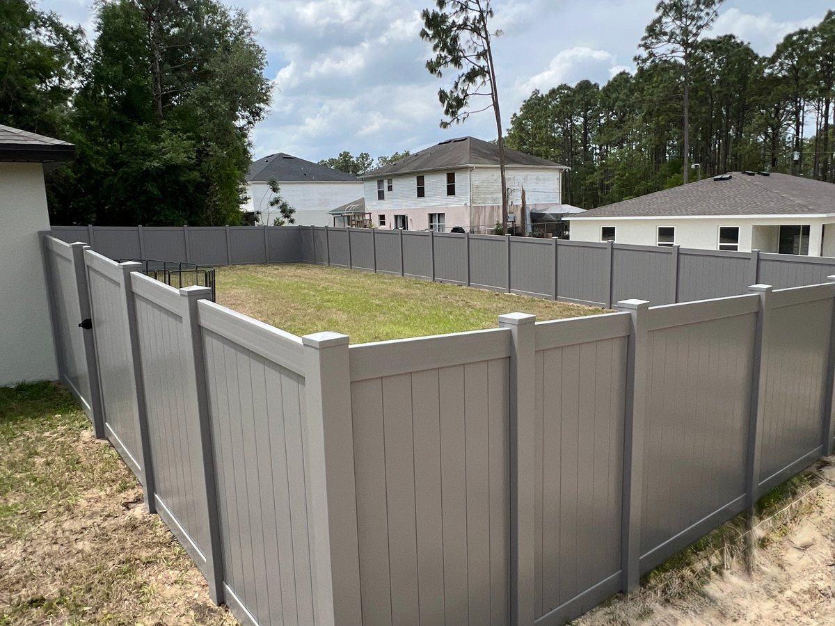 Gray vinyl privacy fence around a backyard in Spring Hill, FL