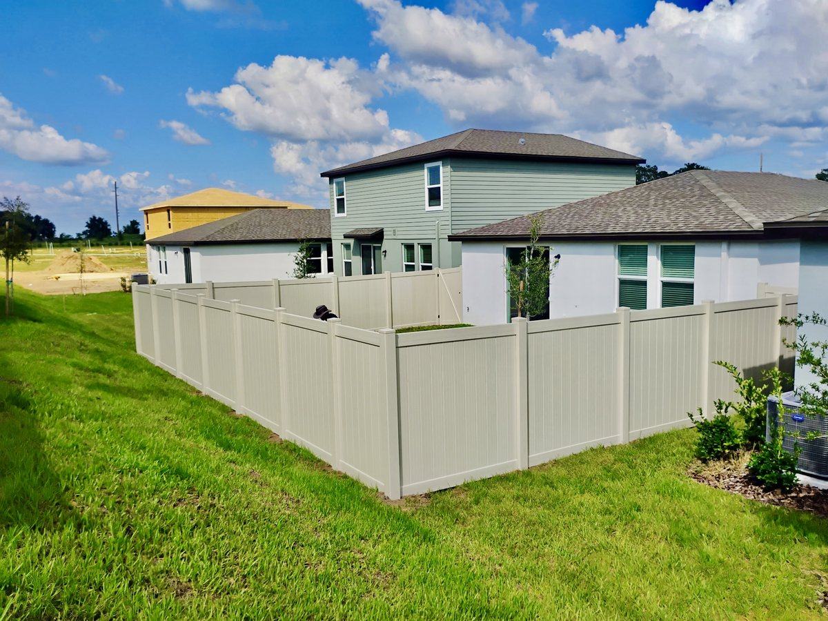 Tan vinyl privacy fence around a new home in Spring Hill, FL