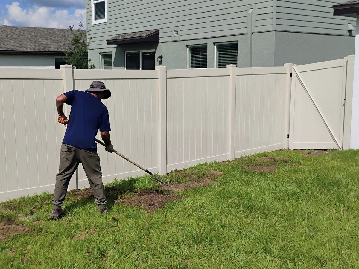 Crew finishing a tan vinyl privacy fence walk gate in Spring Hill, FL