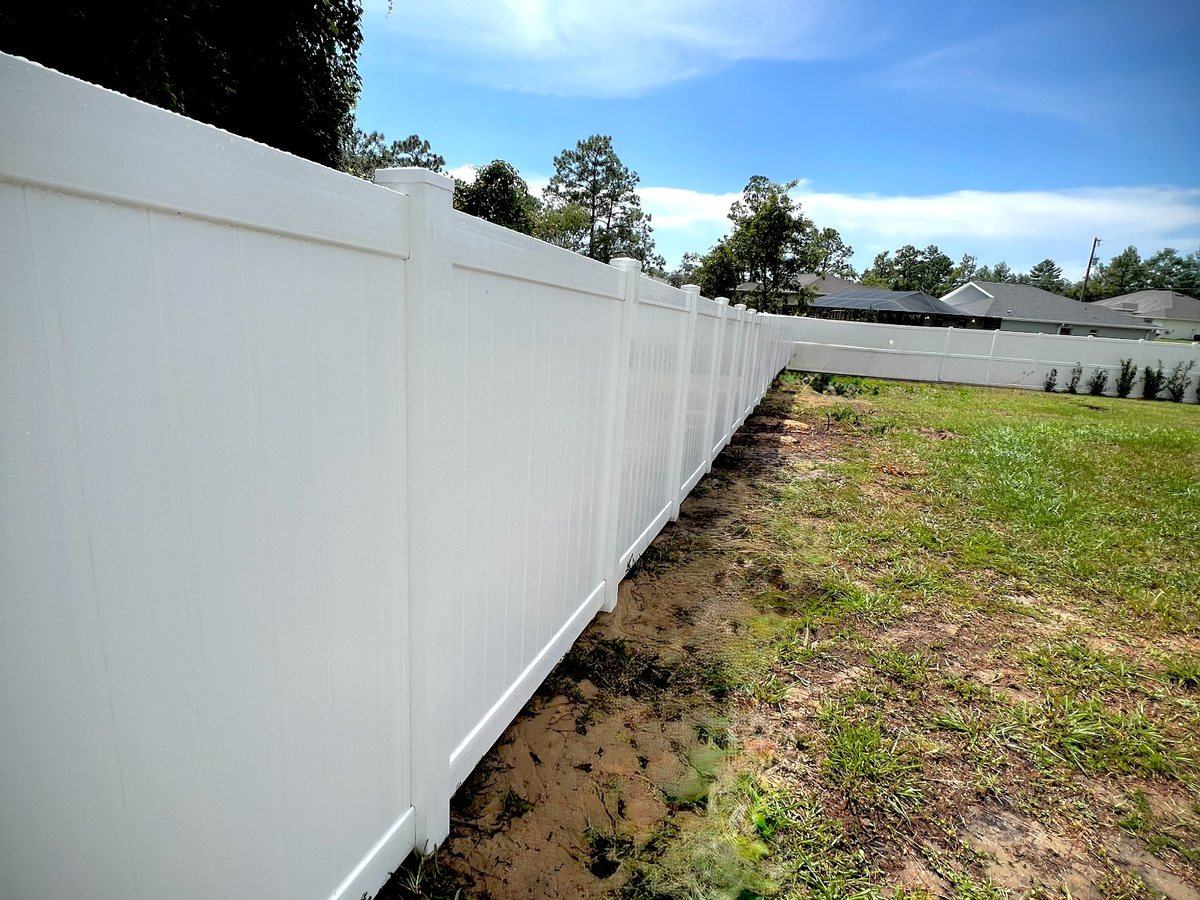 Long run of white vinyl privacy fence in Spring Hill, FL