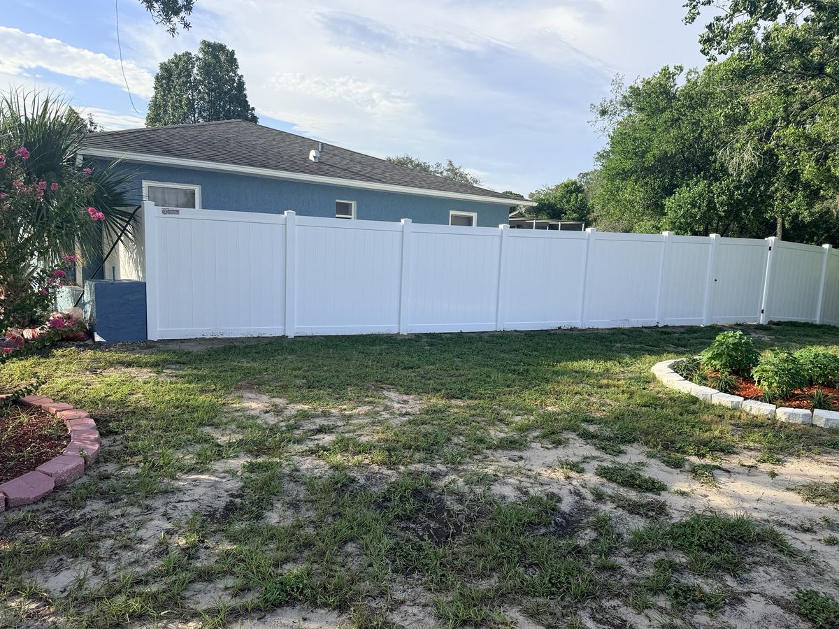 White vinyl privacy fence along the side of a house in Spring Hill, FL