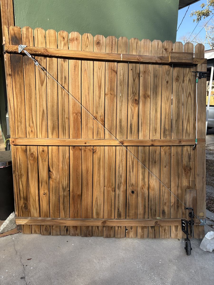 Before: old wood gate with cable brace and caster wheel in St. Petersburg, FL