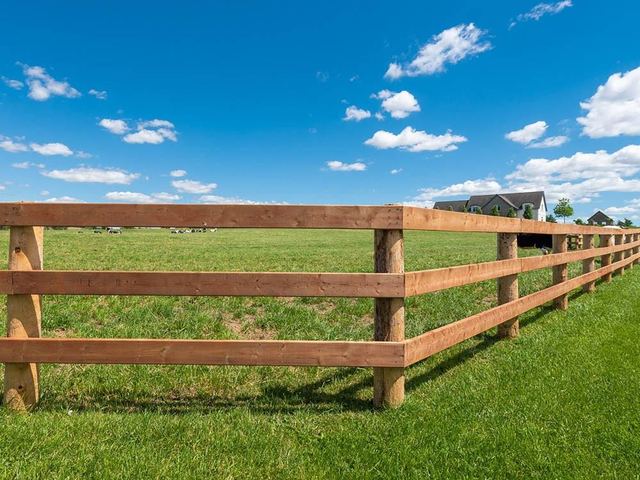 3-rail wood ranch fence along an open pasture