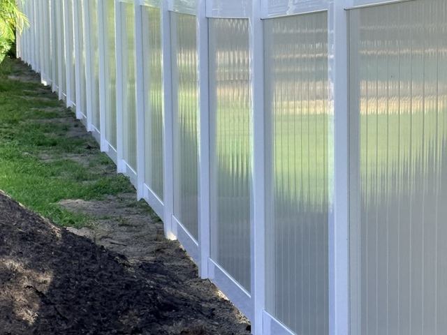 Long white vinyl privacy fence following the grade in Brooksville, FL