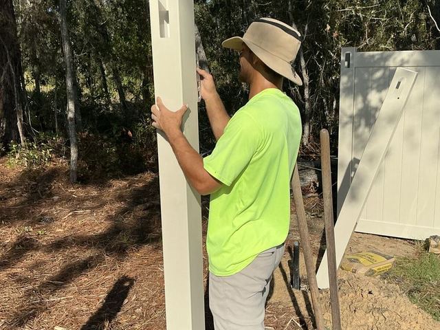Florida Friendly Fencing crew setting a vinyl post