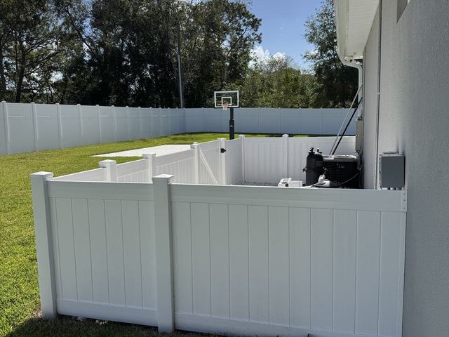 White vinyl pool equipment enclosure with a gate in Hernando County, FL