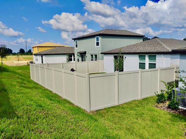 Tan vinyl privacy fence around a new home in Spring Hill, FL