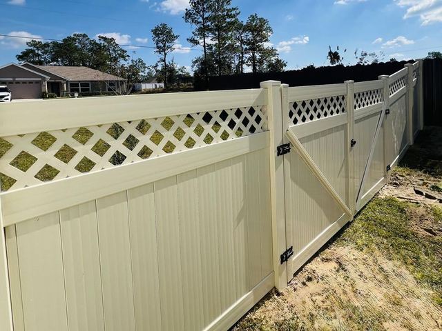 Tan vinyl privacy fence with lattice top in Florida