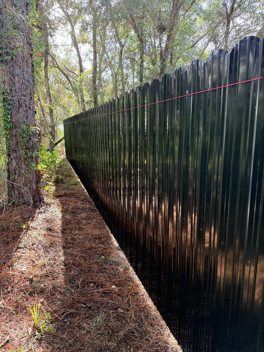 Black Dura Fence privacy fence along a tree line in Weeki Wachee, FL